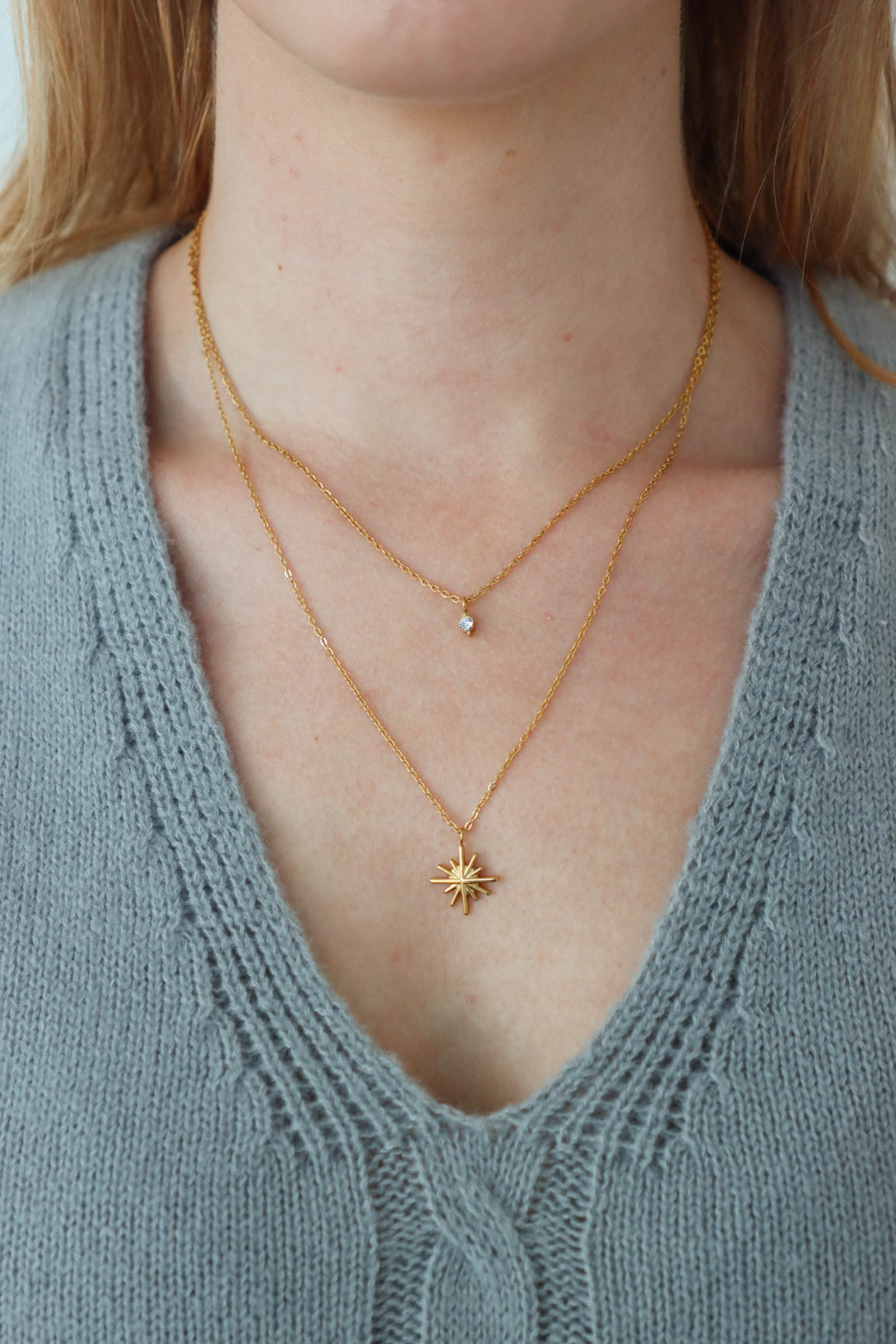 girl wearing gold layered star necklace