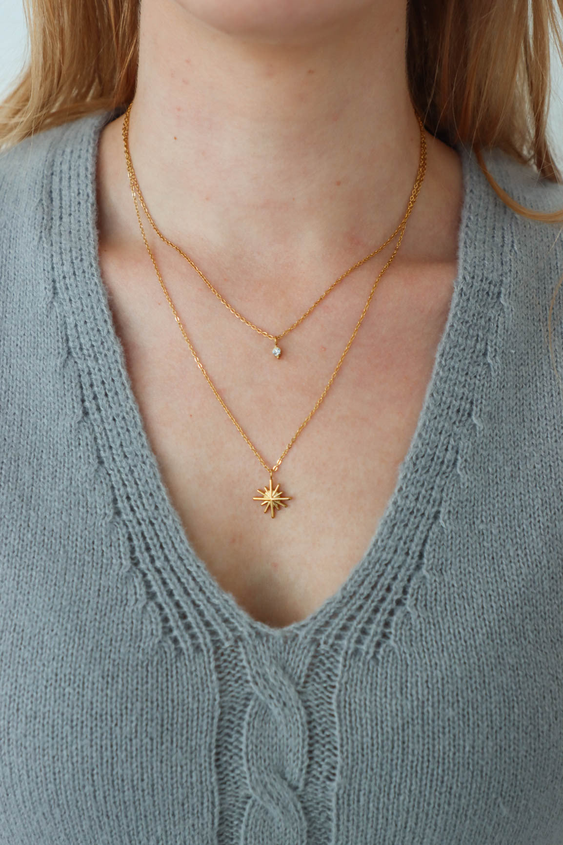 girl wearing gold layered star necklace