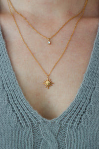 girl wearing gold layered star necklace