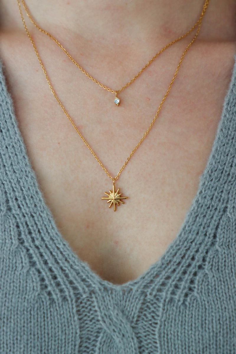 girl wearing gold layered star necklace