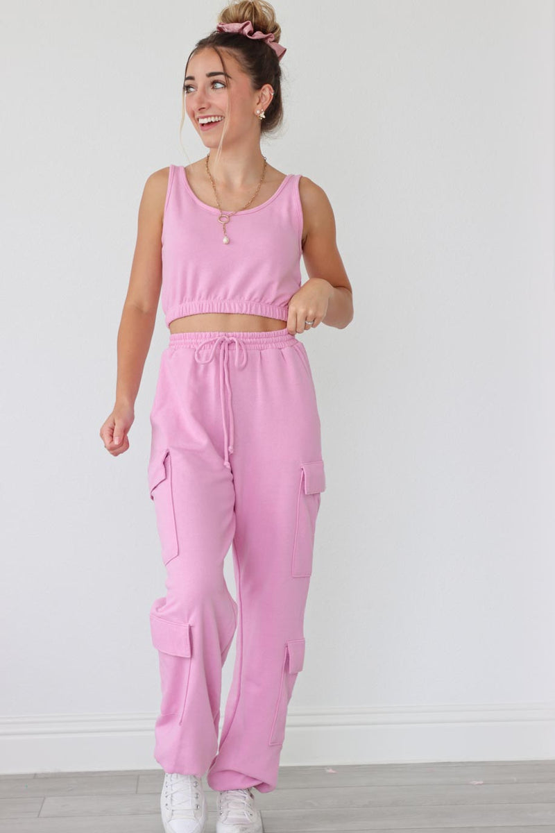 girl wearing pink matching set; sweatpants and sports bra