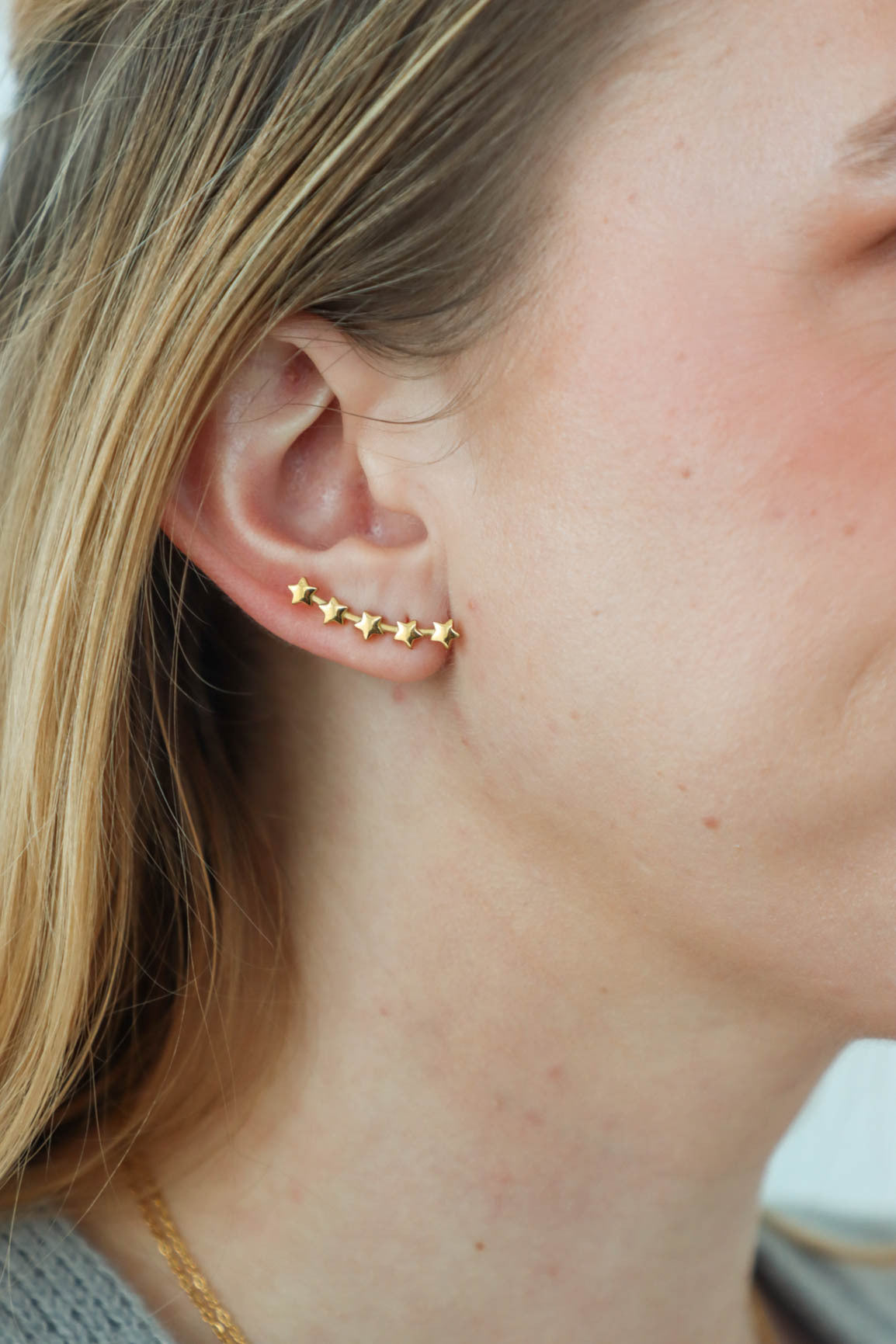 girl wearing gold star earrings