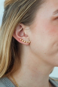 girl wearing gold star earrings