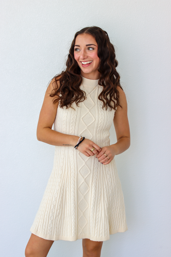 Woman wearing a knit white sweater dress