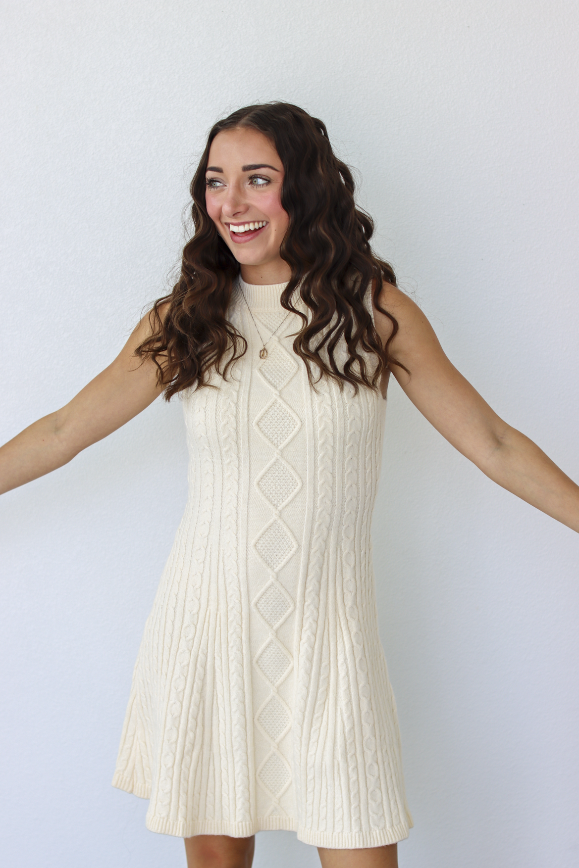 Woman wearing a knit white sweater dress