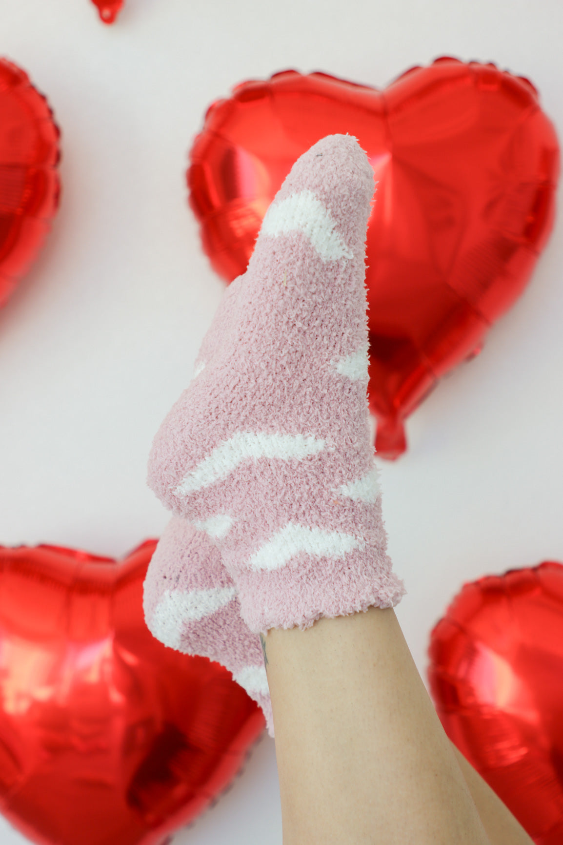light pink fuzzy crew socks with white heart pattern