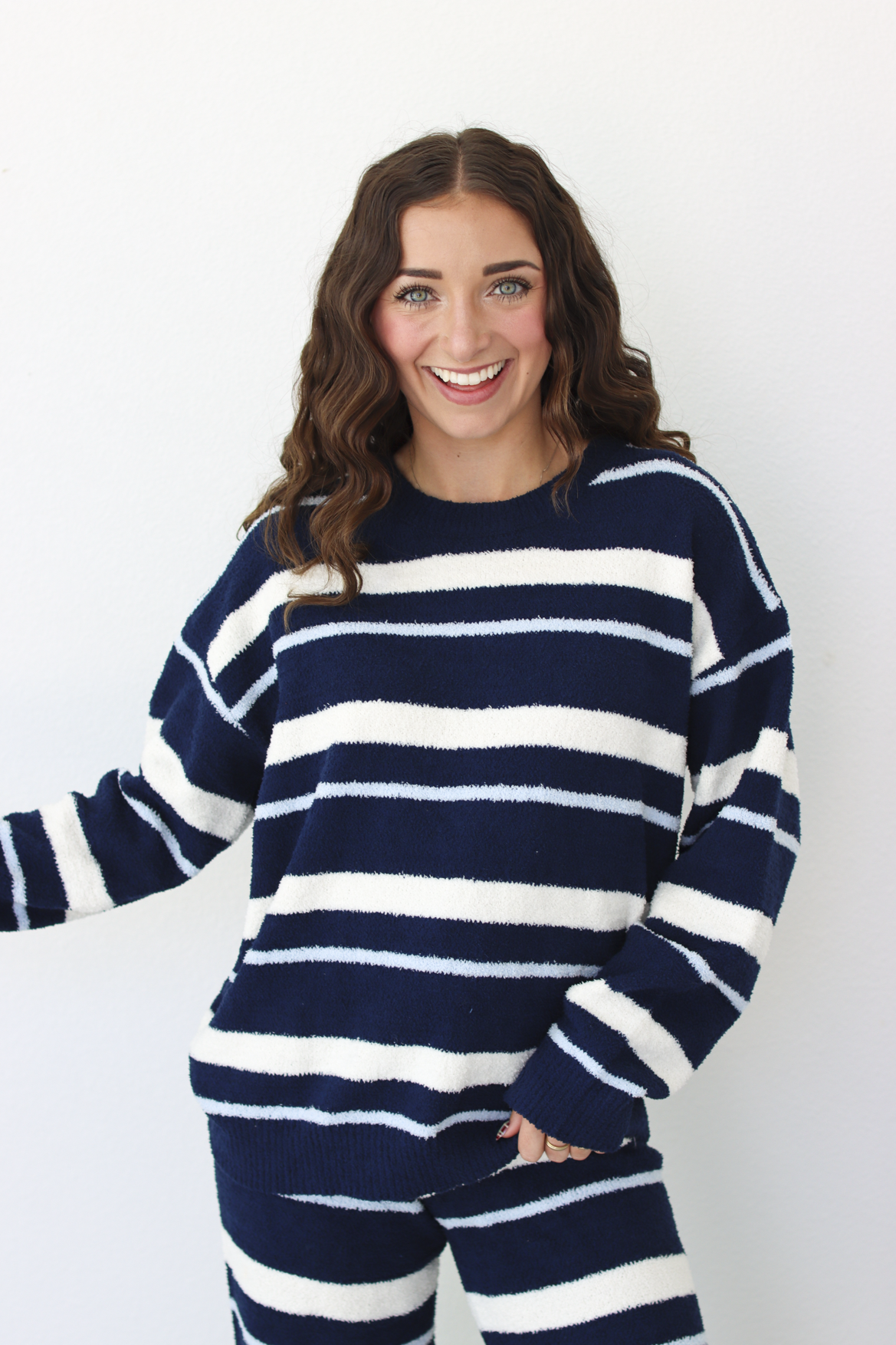 Woman wearing a navy blue and white stripe sweater and pant outfit set 