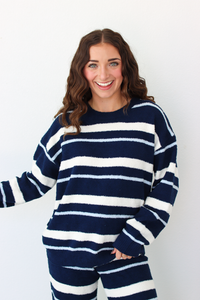 Woman wearing a navy blue and white stripe sweater and pant outfit set 