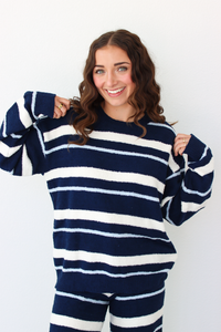 Woman wearing a navy blue and white stripe sweater and pant outfit set 
