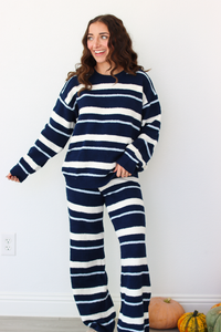 Woman wearing a navy blue and white stripe sweater and pant outfit set 
