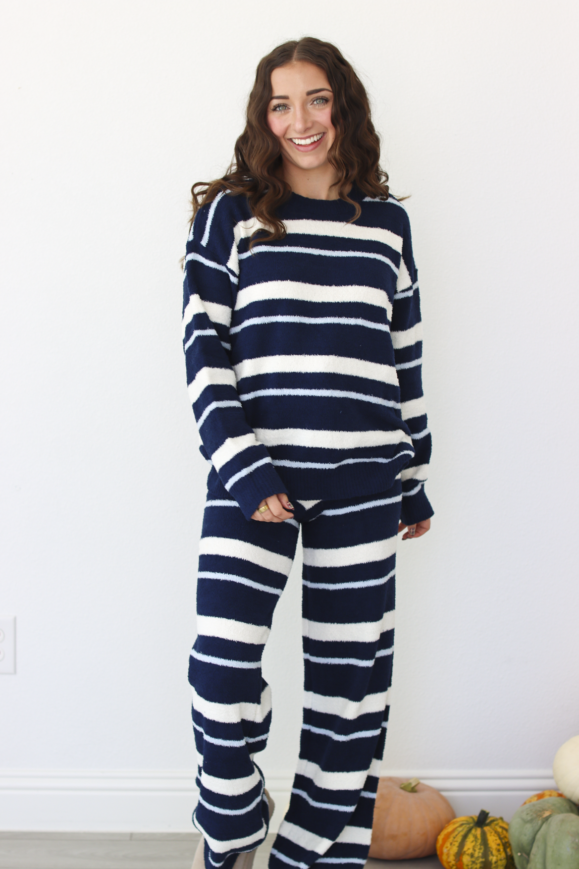 Woman wearing a navy blue and white stripe sweater and pant outfit set 