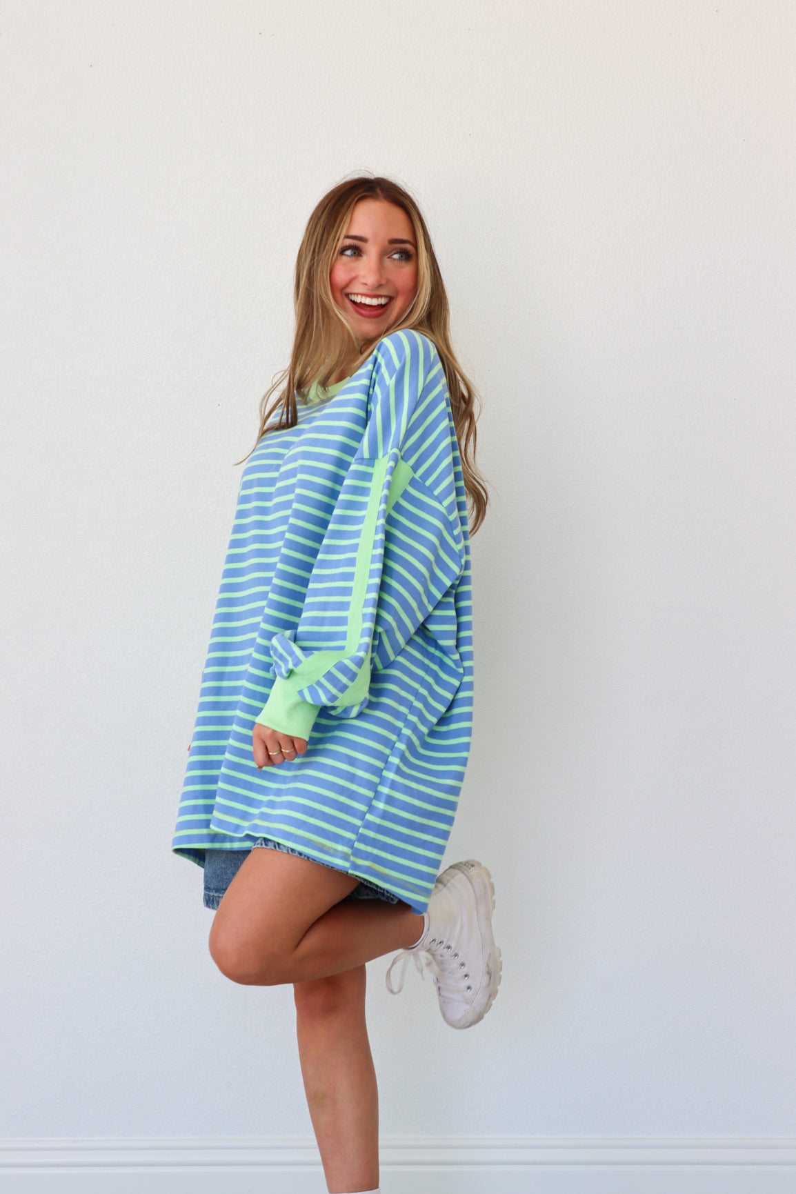 Woman wearing a blue and green striped dress with a white background