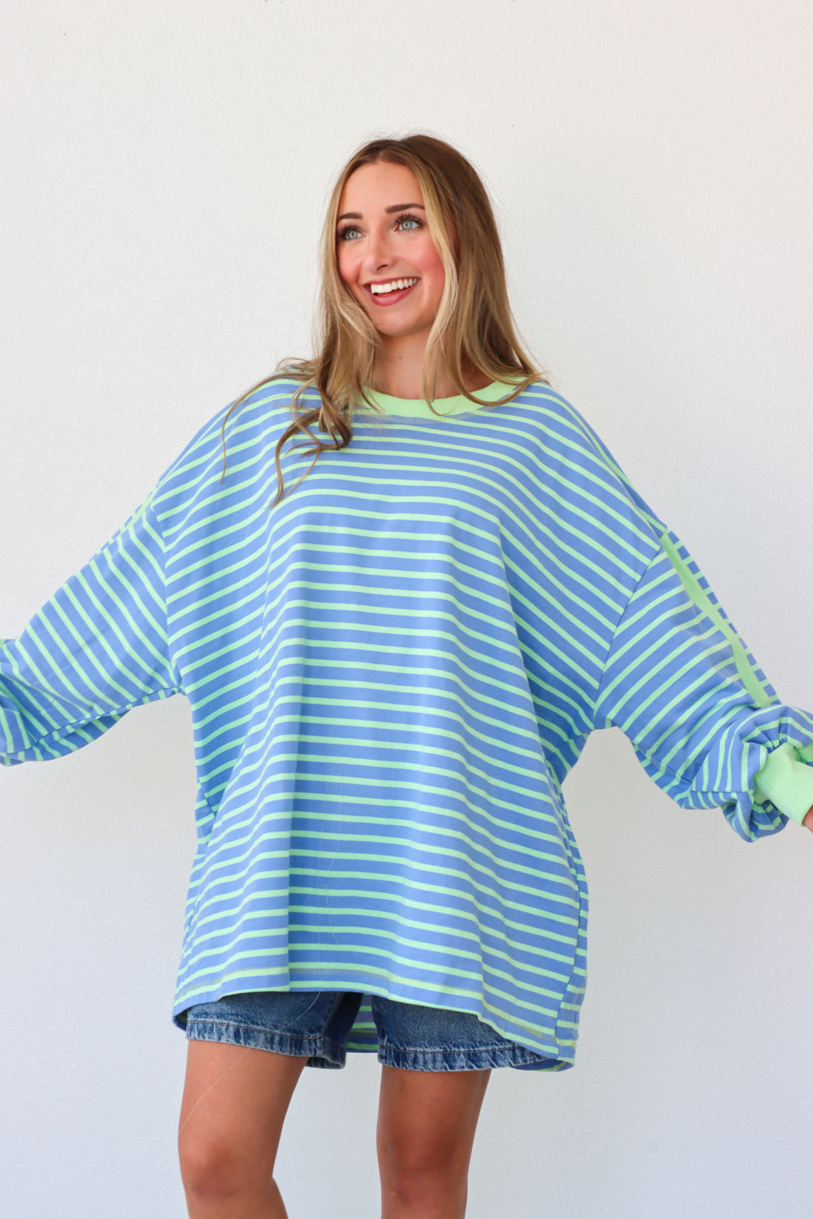 Woman wearing a blue and green striped dress against a white background