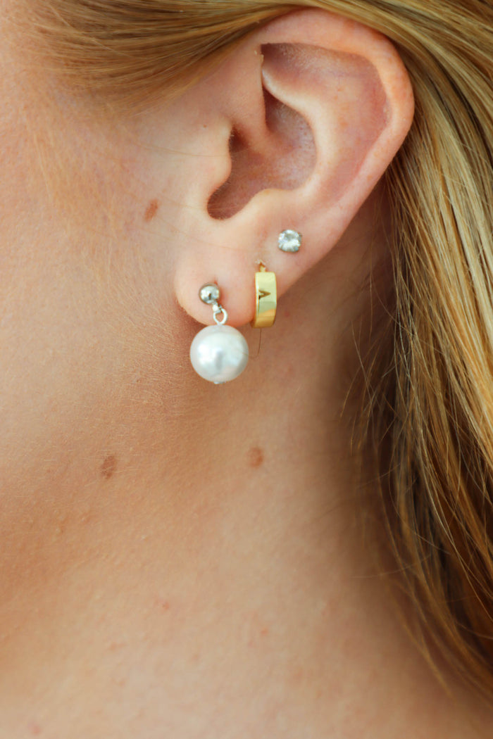 girl wearing silver pearl earrings