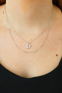 girl wearing silver flower layered necklace