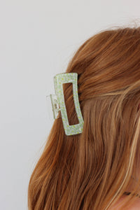 girl wearing green floral hair clip