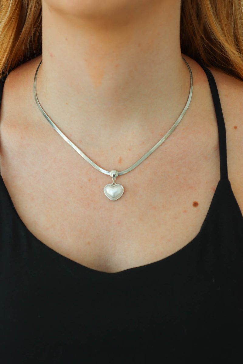 girl wearing silver heart necklace