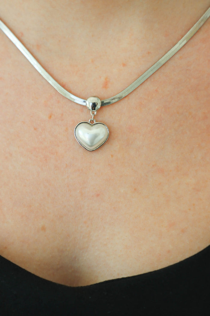 girl wearing silver heart necklace