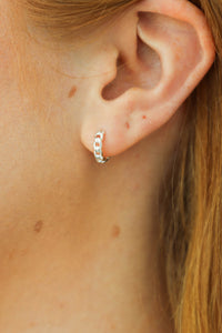 girl wearing silver huggie hoop earrings