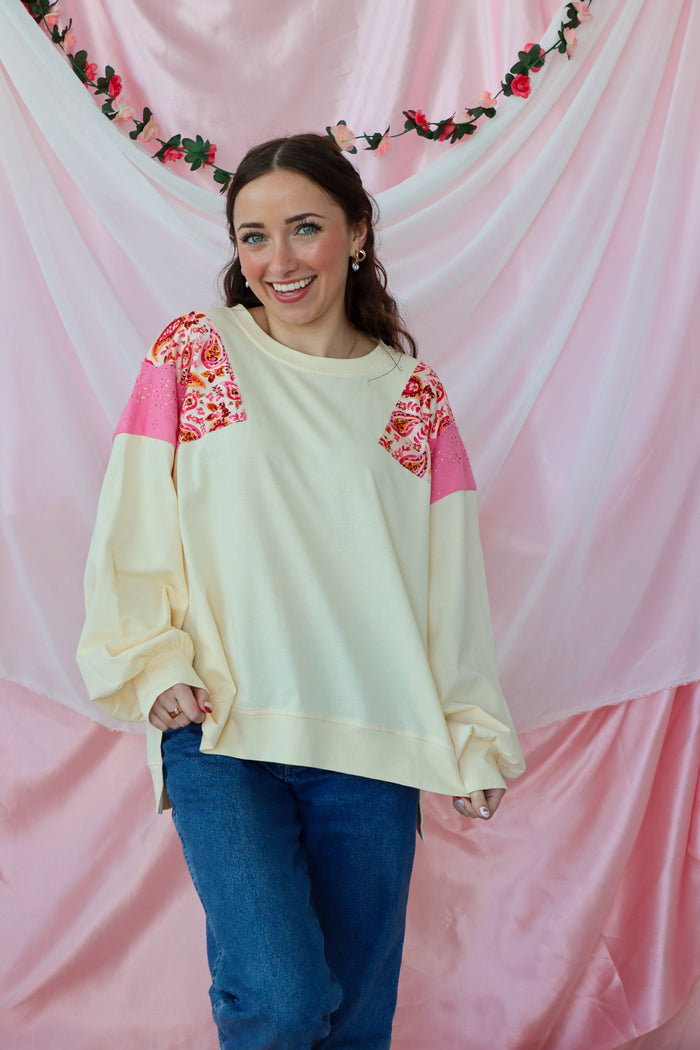 girl wearing a cream paisley top