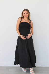 girl wearing long black drop waist dress