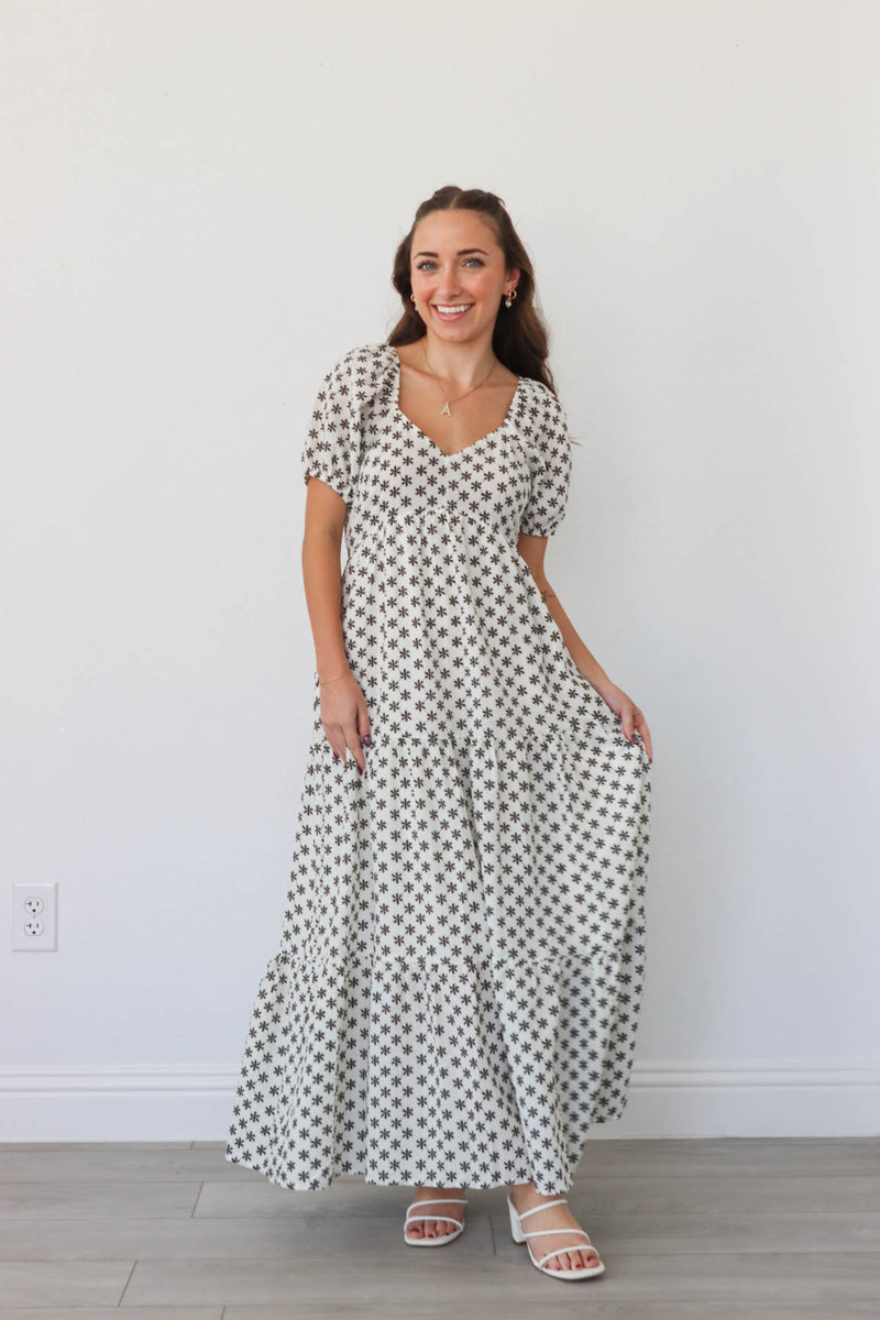 girl wearing white long dress with black flowers