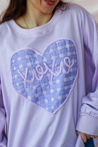 girl wearing light purple "xoxo" top