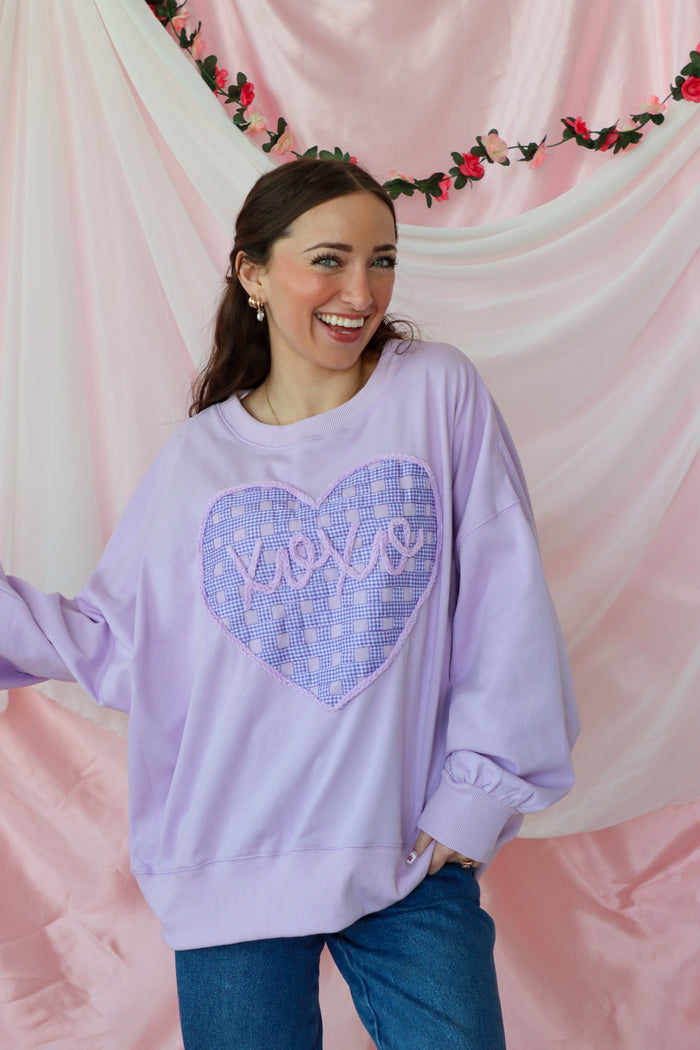 girl wearing light purple "xoxo" top