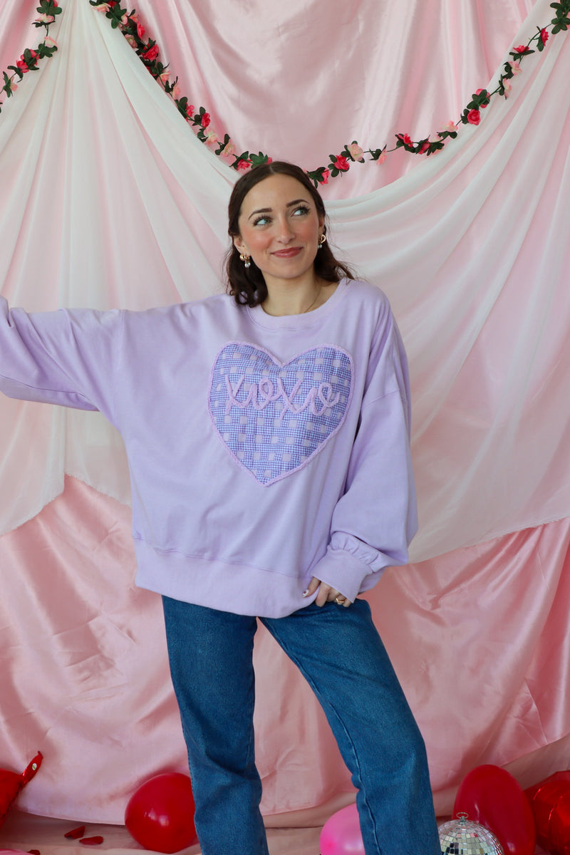 girl wearing light purple "xoxo" top