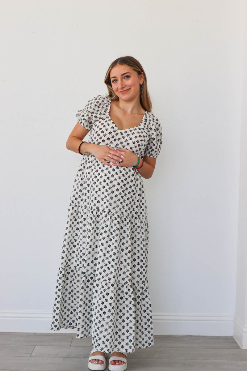 girl wearing white long dress with black flowers