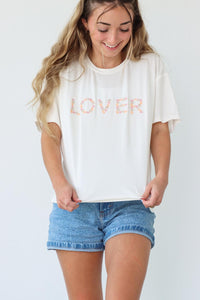 girl wearing white t-shirt with embroidered "lover" graphic