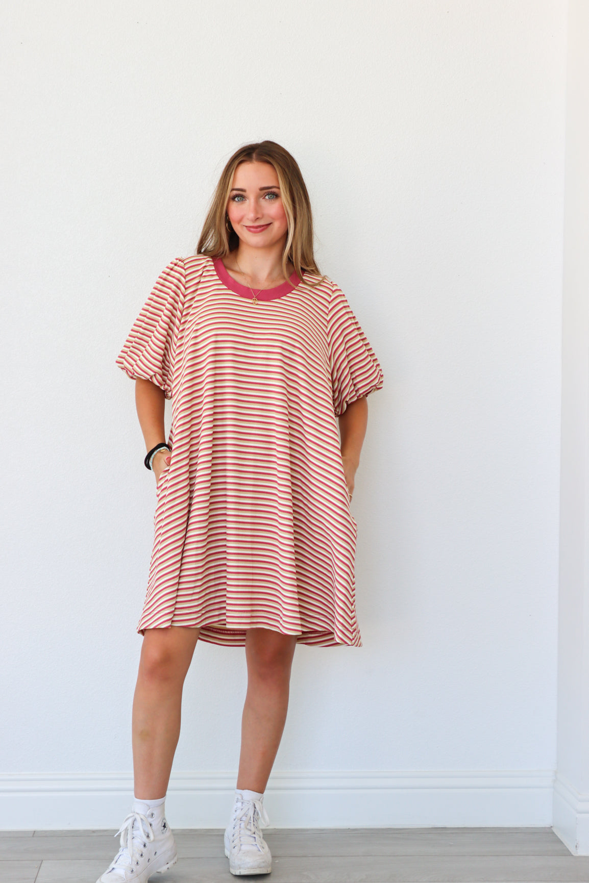 Woman wearing a red and white striped dress against a white background