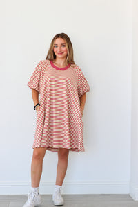 Woman wearing a red and white striped dress against a white background