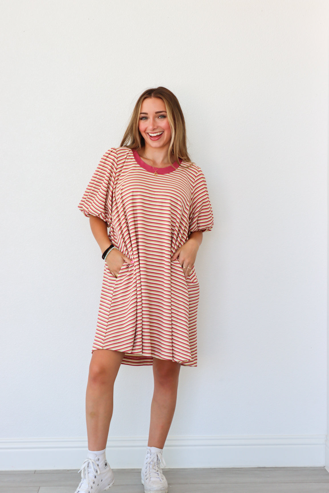Woman wearing a red and white striped dress against a white background