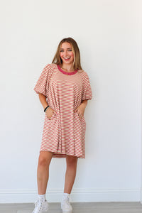 Woman wearing a red and white striped dress against a white background