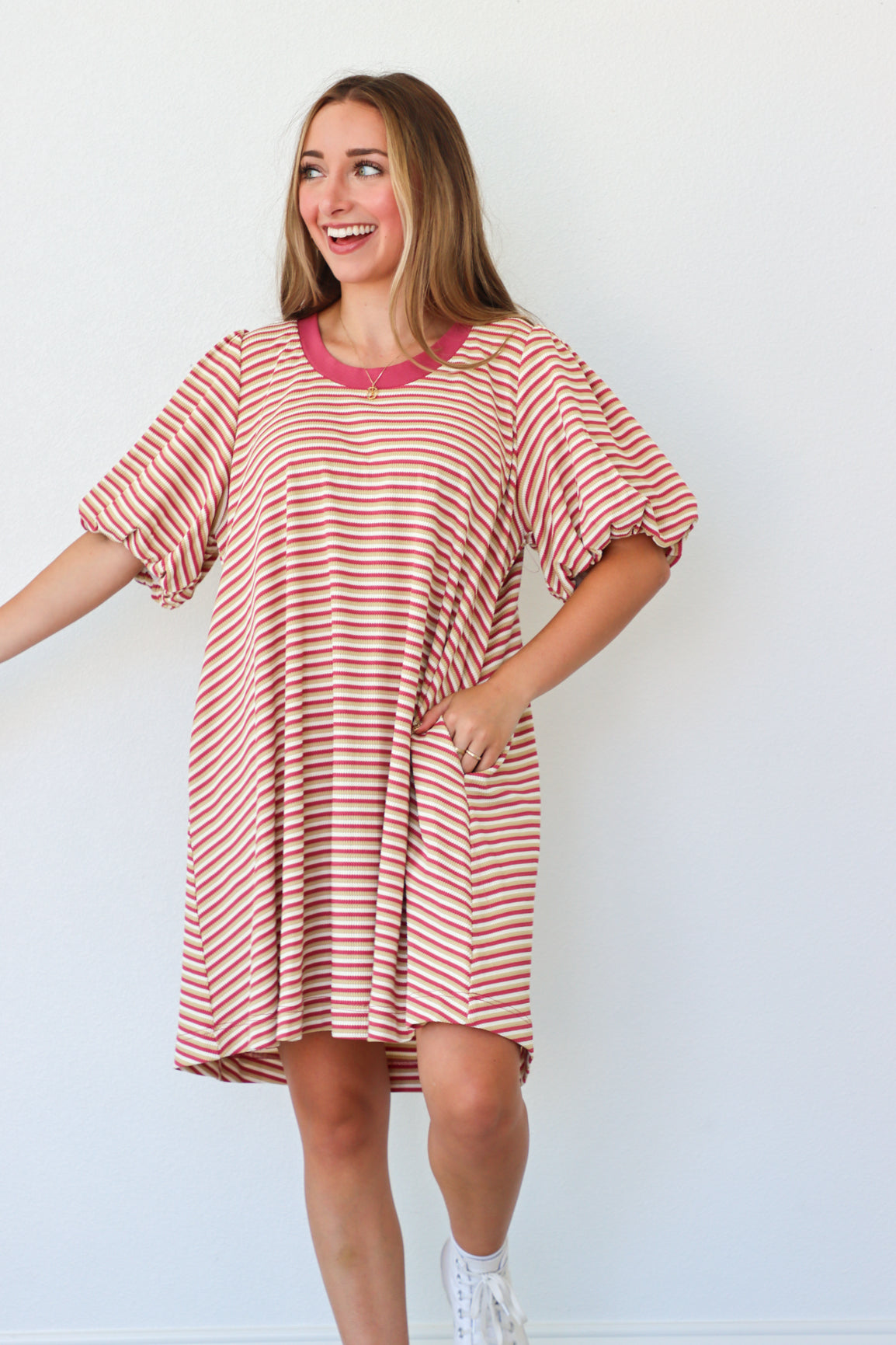 Woman wearing a red and white striped dress against a white background