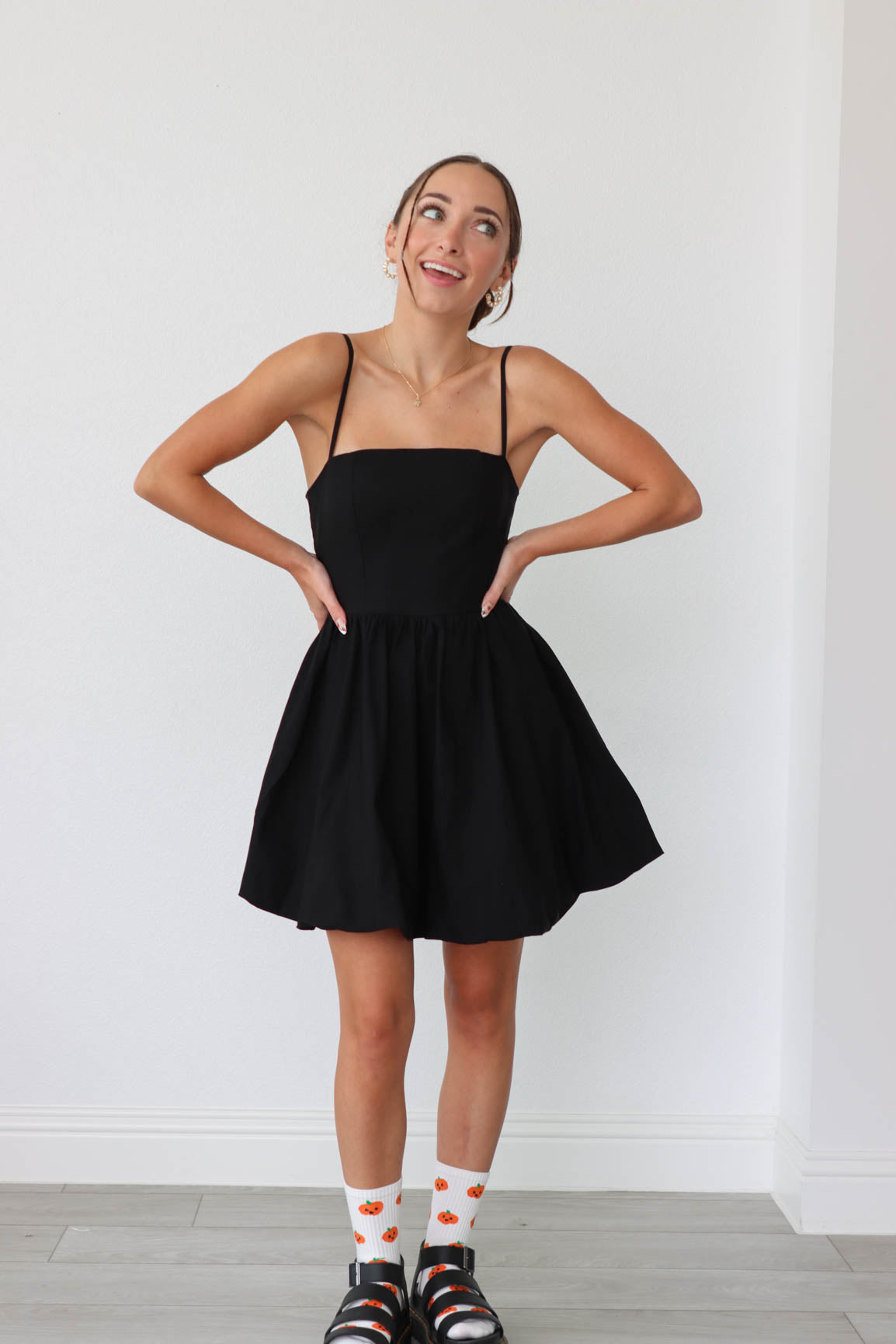 girl wearing short black dress with thin straps