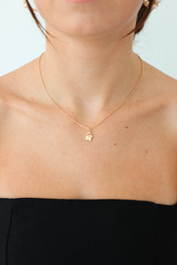 girl wearing small, gold ghost necklace