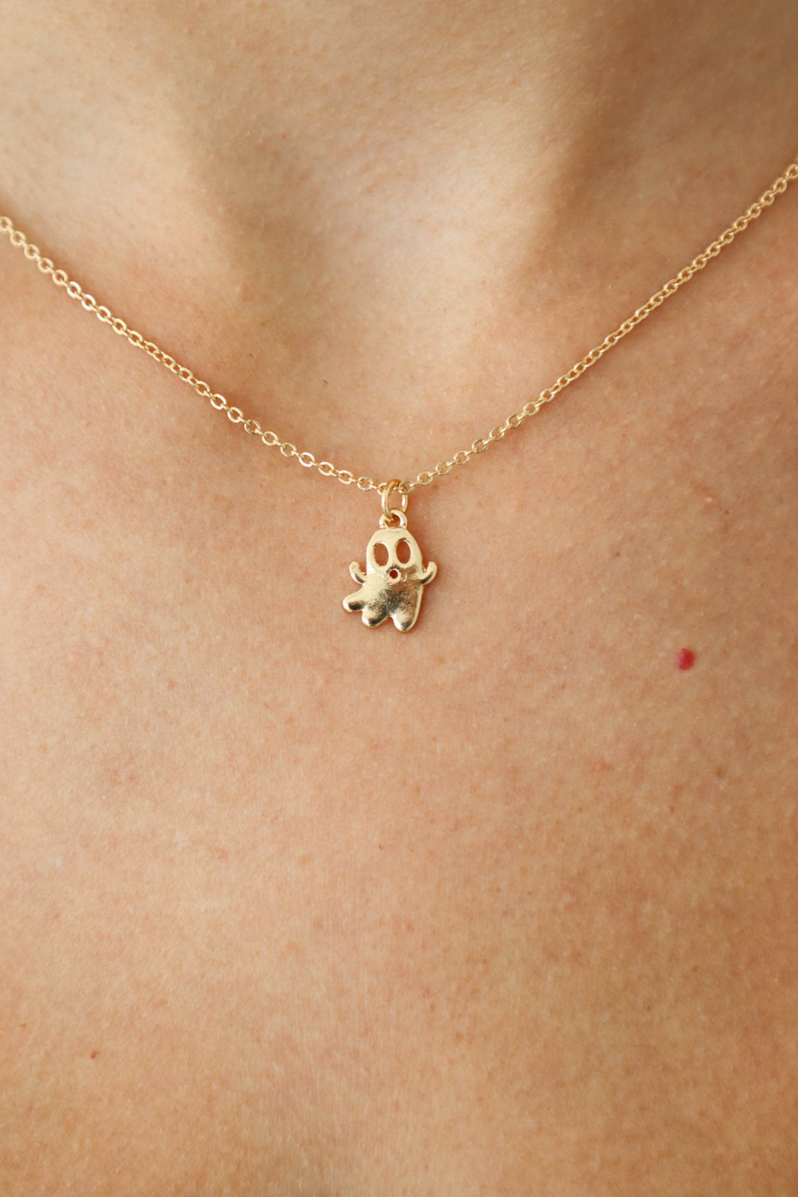 small, gold ghost necklace