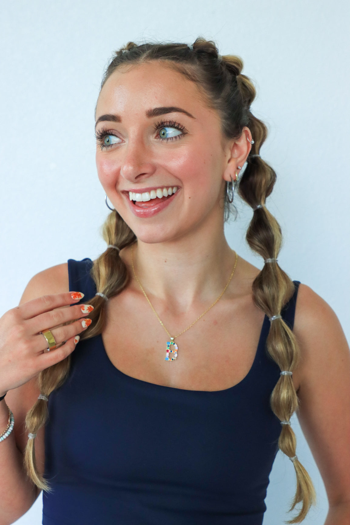 Woman with braided hair wearing a blue top against a light background