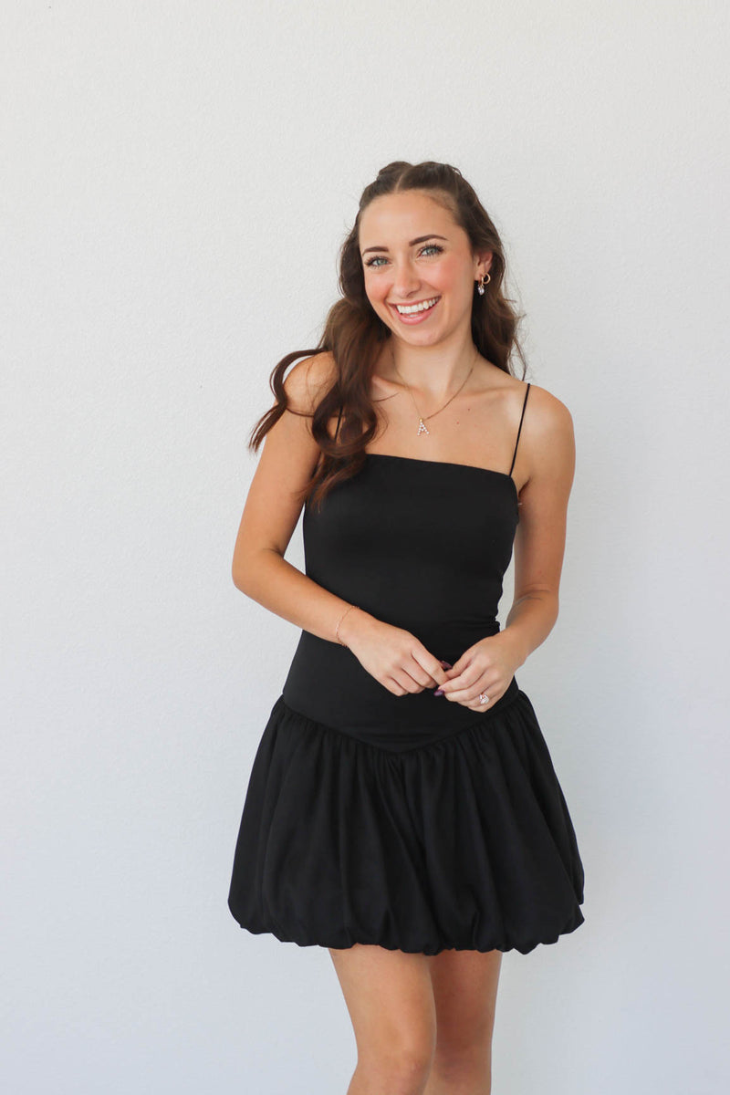 girl wearing short black drop waist dress