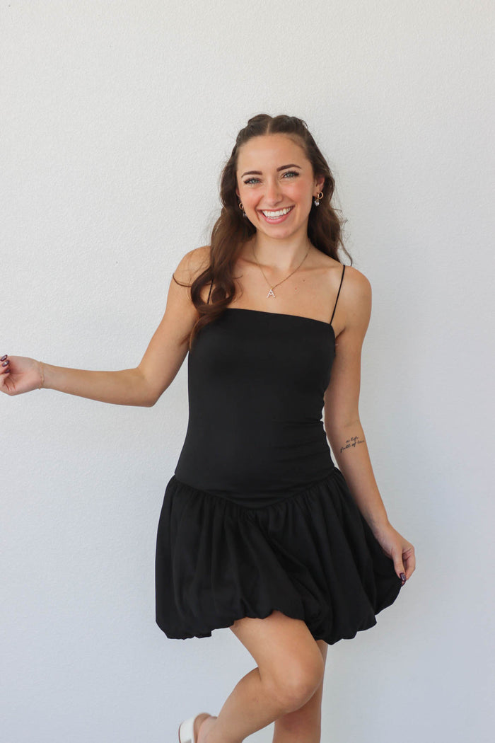 girl wearing short black drop waist dress