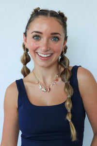 Woman with braided hair wearing a blue top against a light background