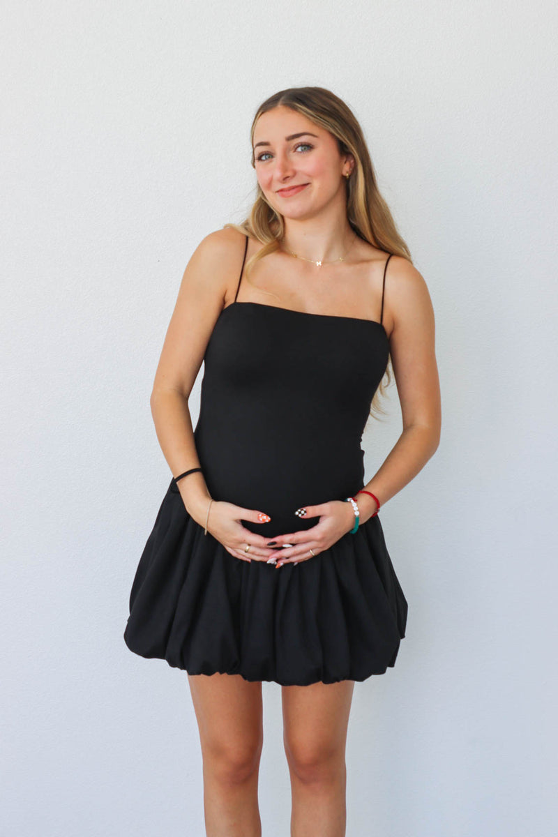 girl wearing short black drop waist dress