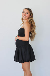 girl wearing short black drop waist dress