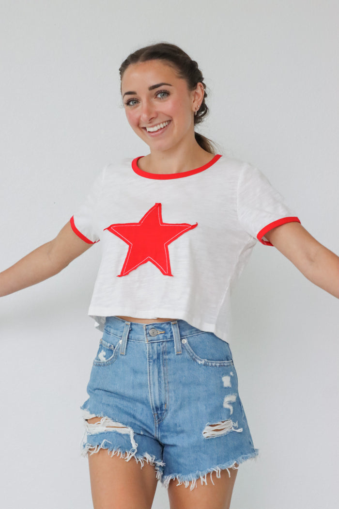 girl wearing white t-shirt with red embroidered heart detailing