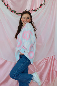 girl wearing light blue and pink xoxo sweater