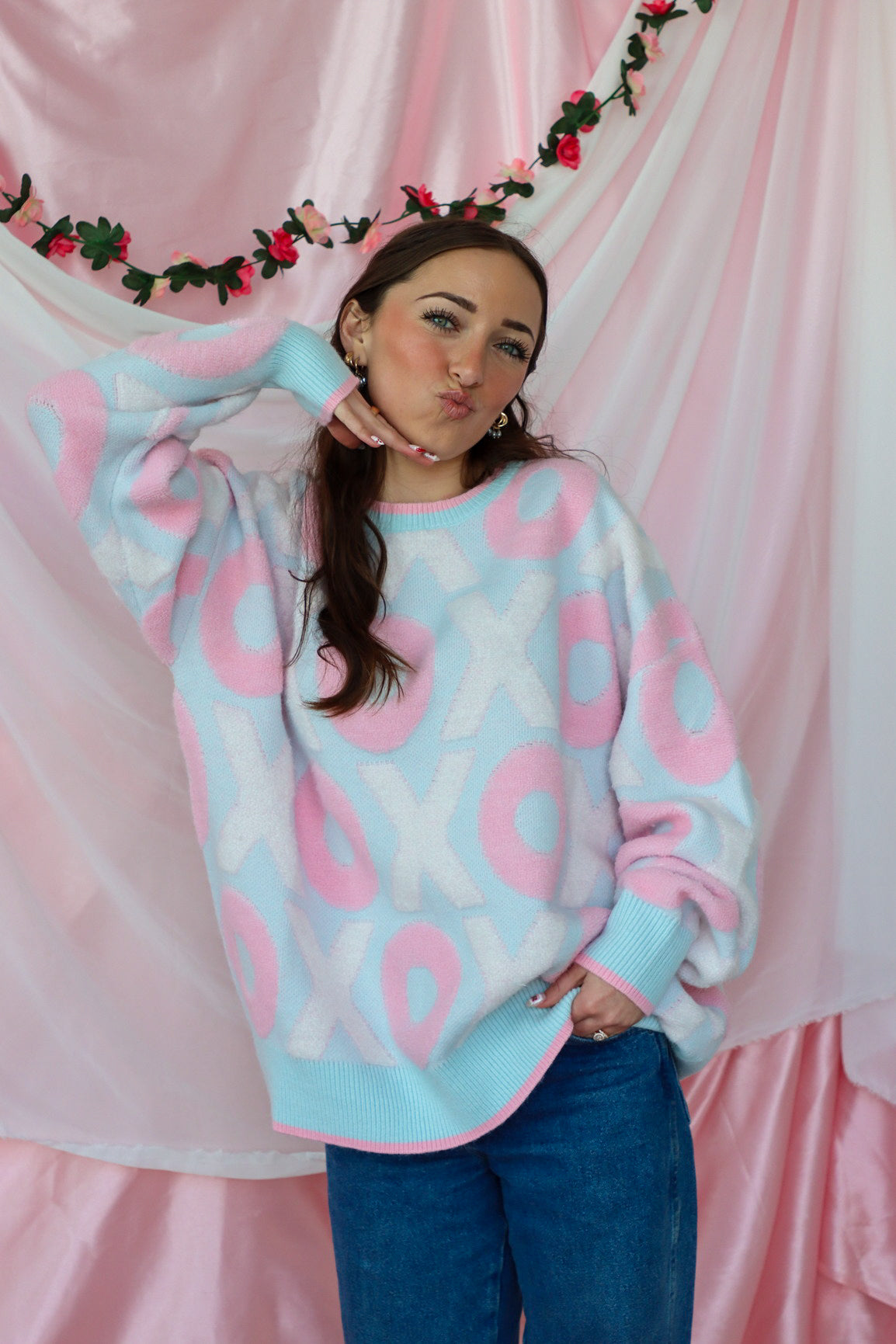 girl wearing light blue and pink xoxo sweater