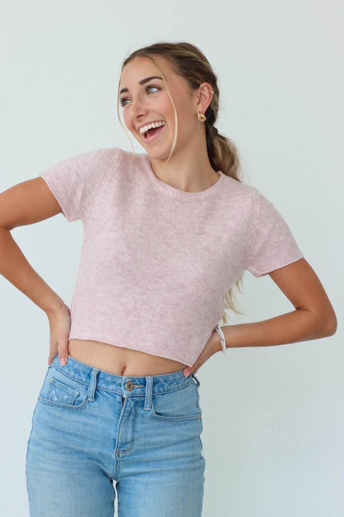 girl wearing pink cropped knit fuzzy short sleeved top