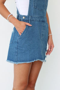 girl wearing denim overall skirt with western buckles